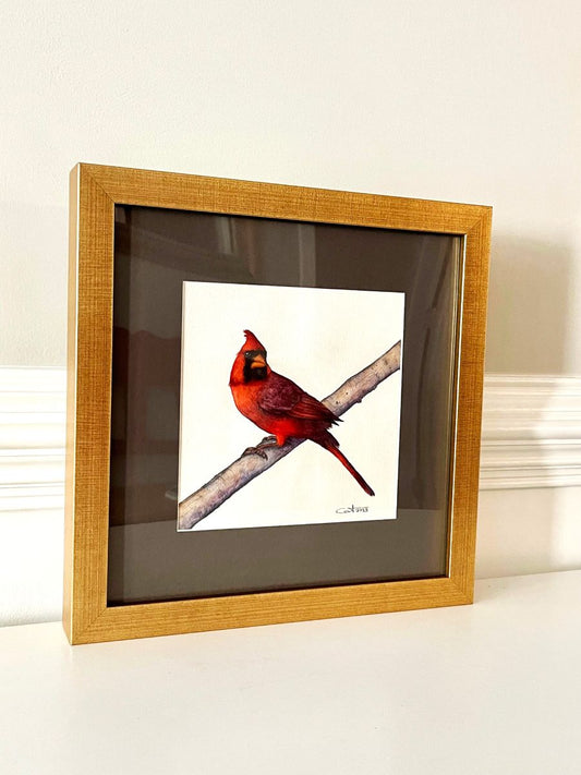 Framed painting of a red cardinal bird on a branch with a gold frame