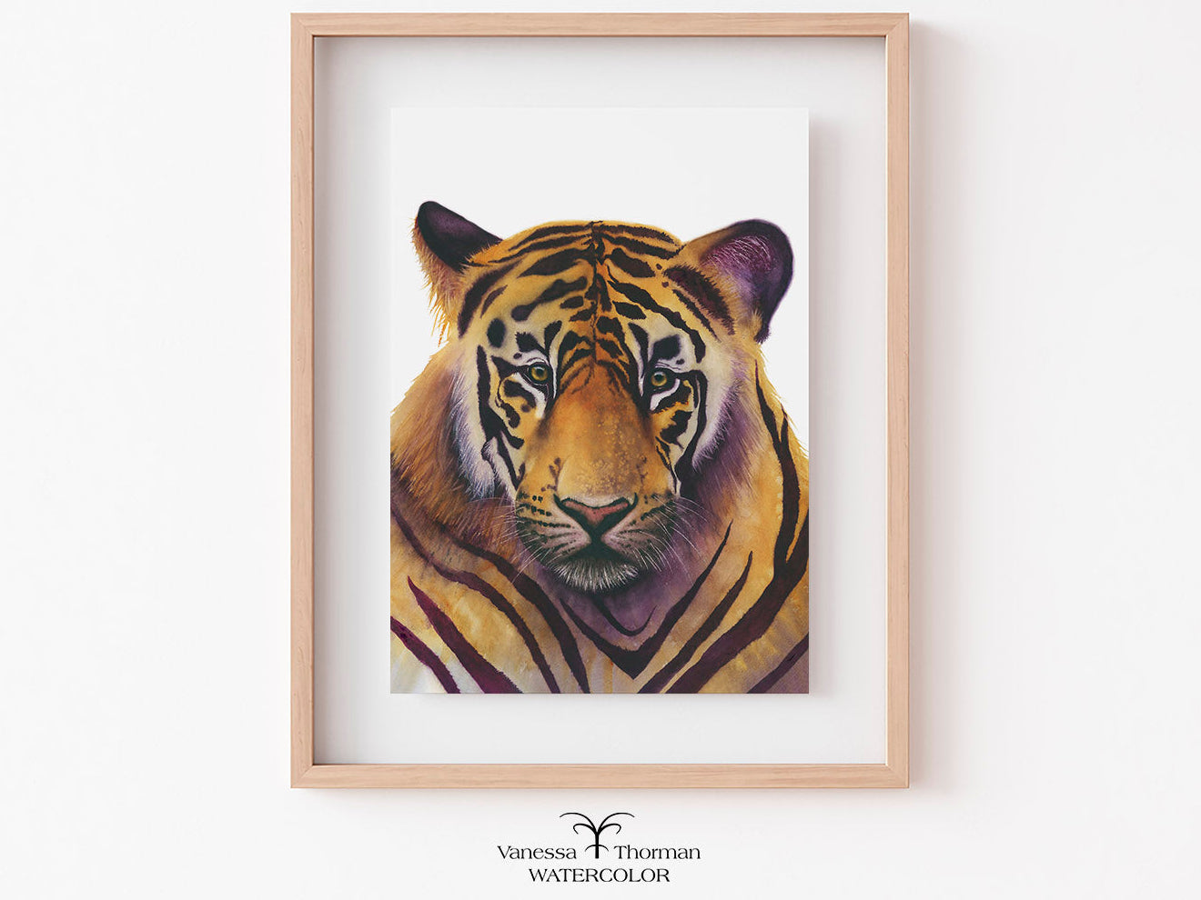 Framed watercolor painting of a tiger on a white wall
